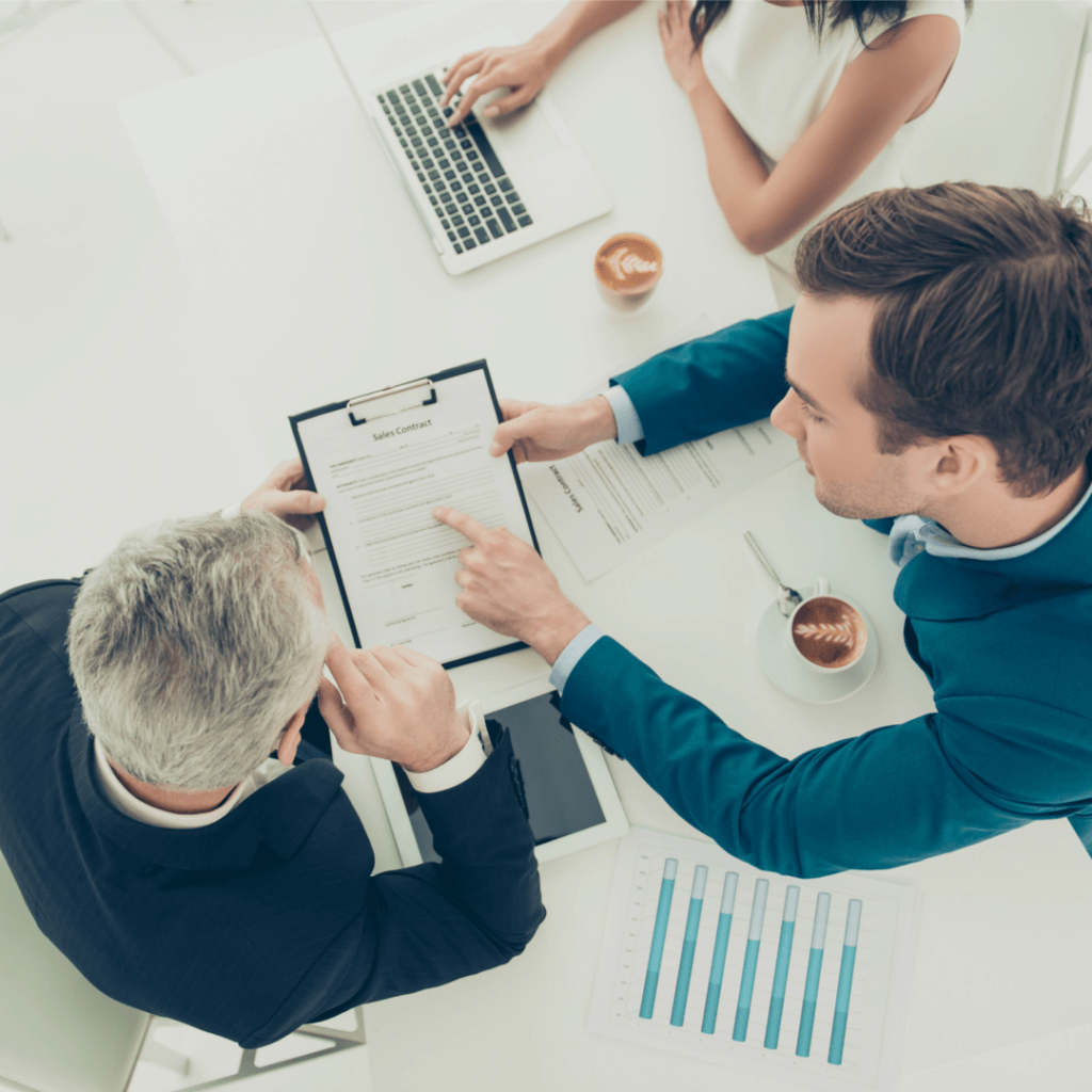 Business professionals engaged in a discussion about a business plan during a meeting at Capital Premium Financing.