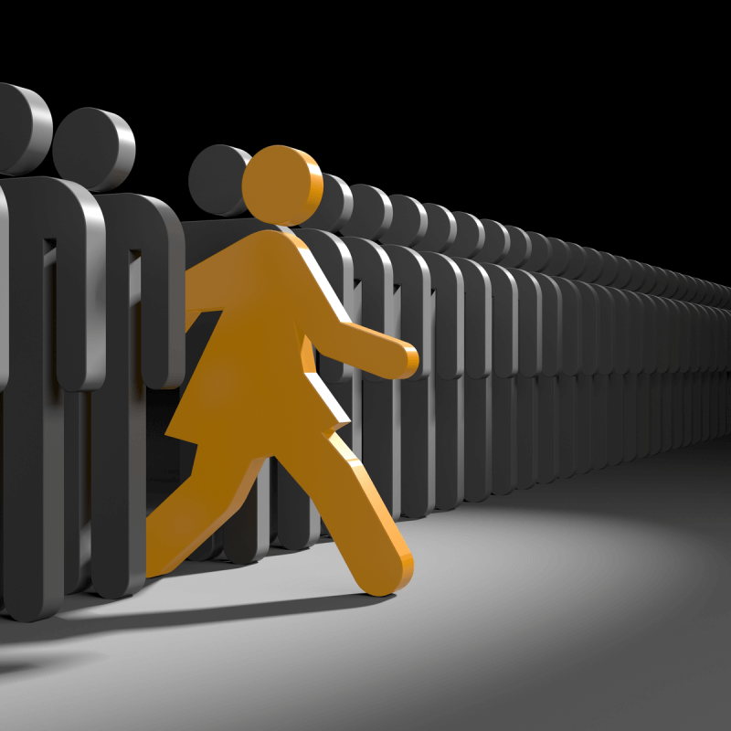 A person walking confidently in front of a large crowd, representing Capital Premium Financing's engagement with the community.