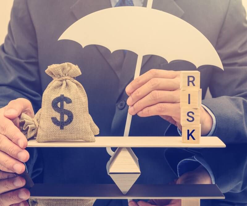 Businessman weighing risk against money on scales, symbolizing financial decision-making for Capital Premium Financing.