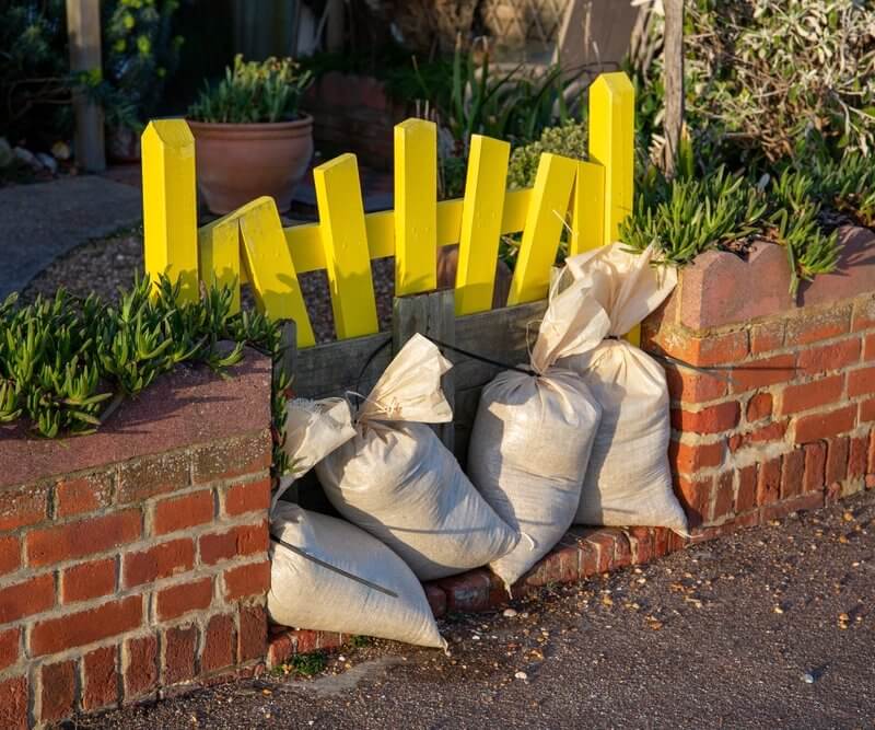 A yellow gate secured by sandbags, associated with Capital Premium Financing, suggesting a protective measure.