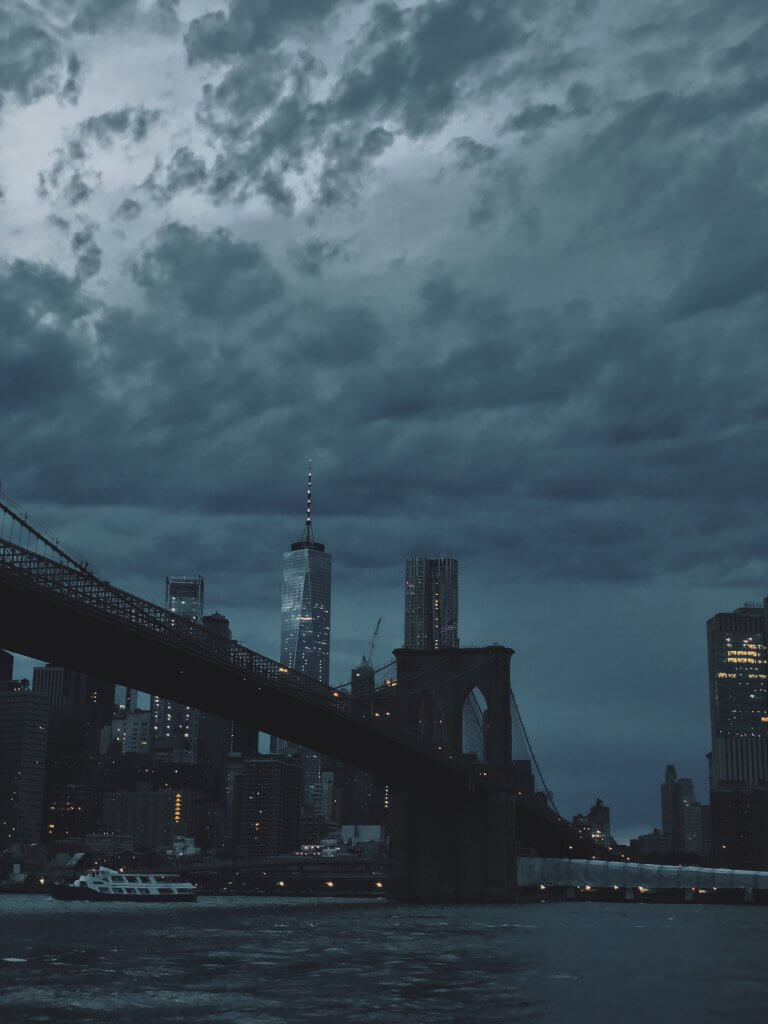 A cloudy sky looms over the iconic Brooklyn Bridge, symbolizing resilience and connection in urban landscapes.