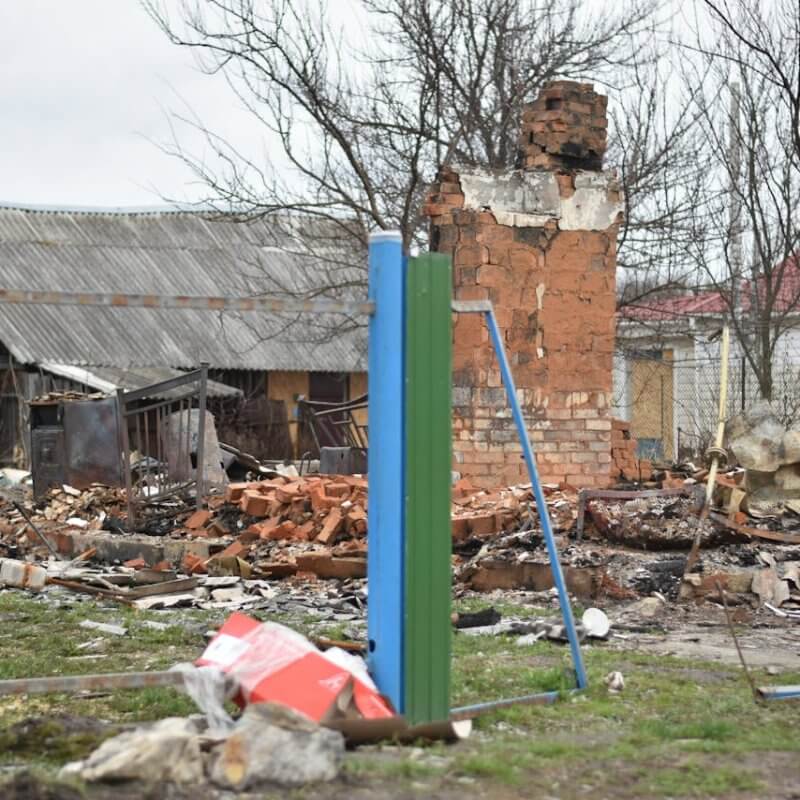 A charred house in ruins, surrounded by debris, illustrating the aftermath of a devastating fire.