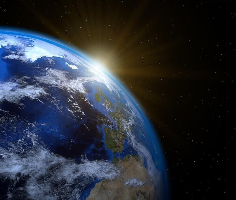 A view of Earth from space illuminated by sunlight, showcasing the planet's beauty and vastness.