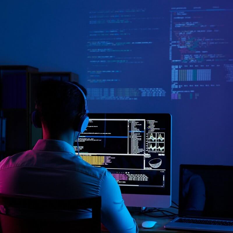 A man focused on a computer, working with a monitor and keyboard, representing Capital Premium Financing.