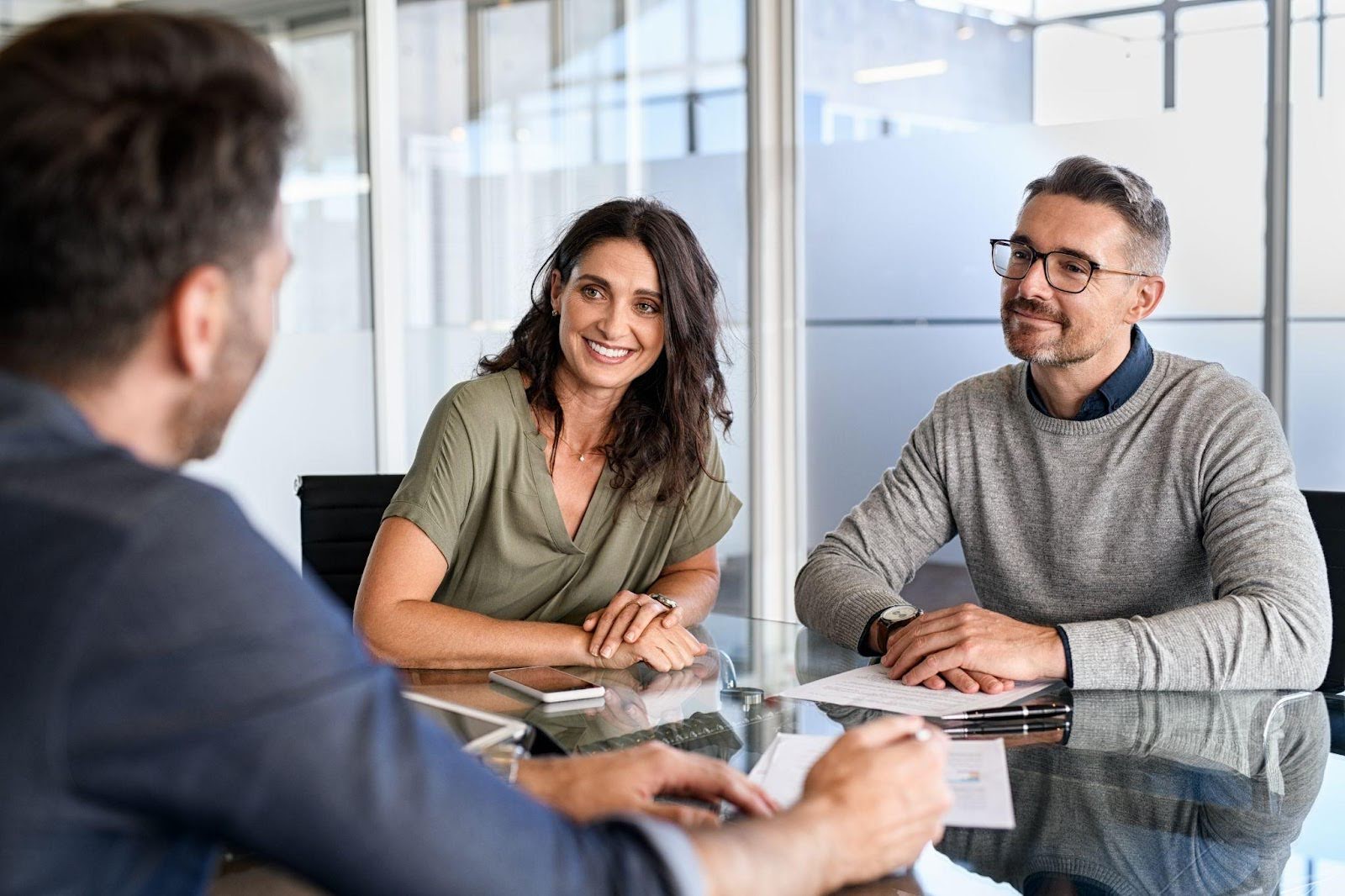 A man and woman collaborate on a project at a table in an office