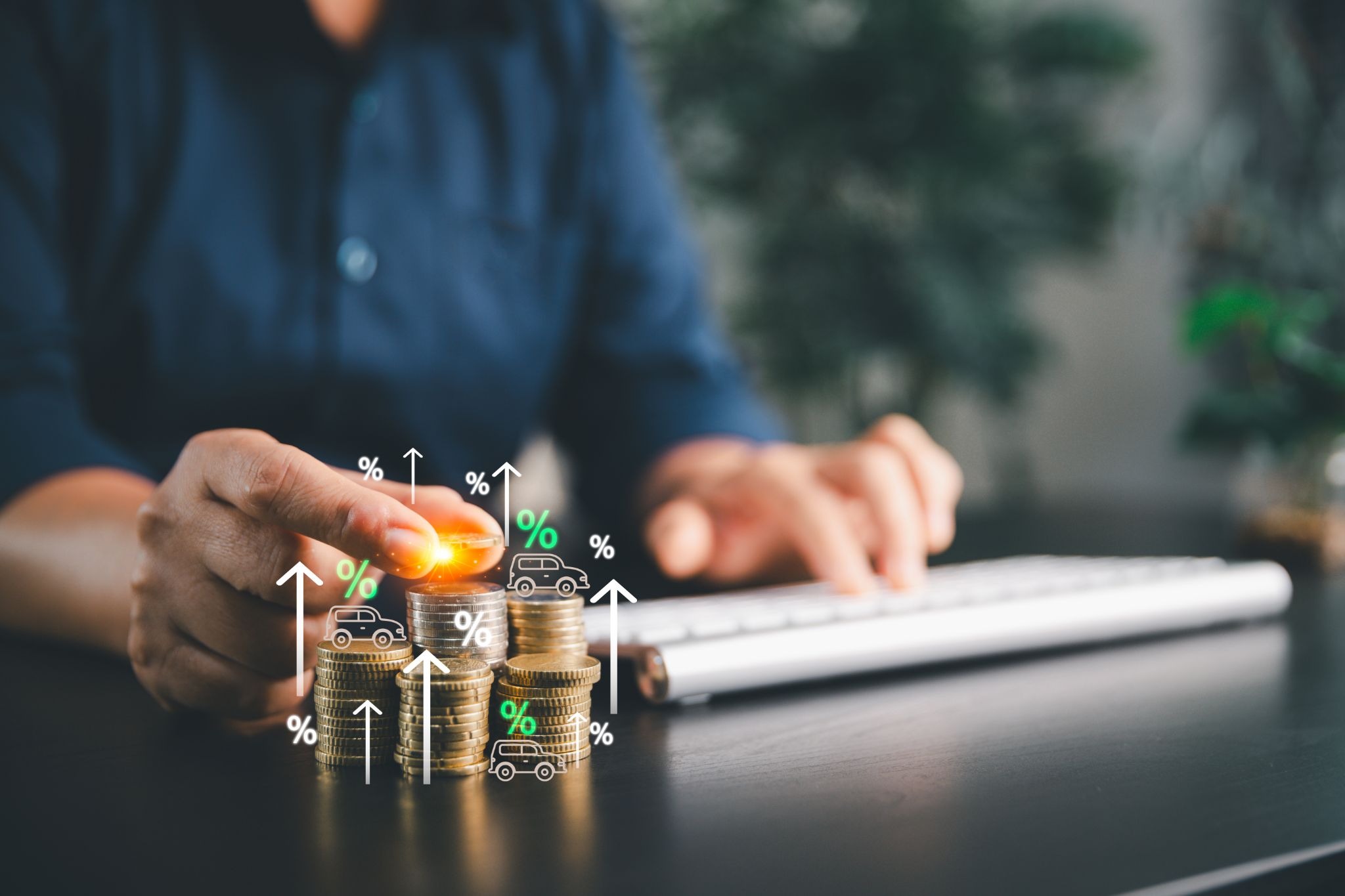 Person stacking coins next to a keyboard with rising interest and car loan icons.